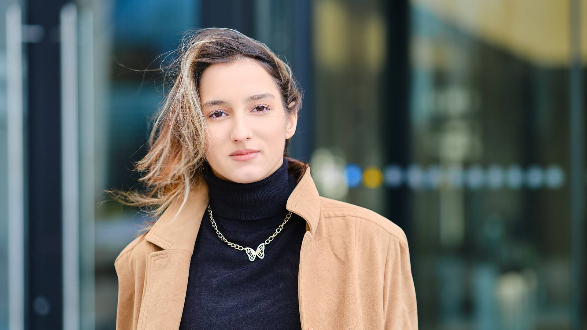 Frau mit Kette vor Geb&auml;ude.