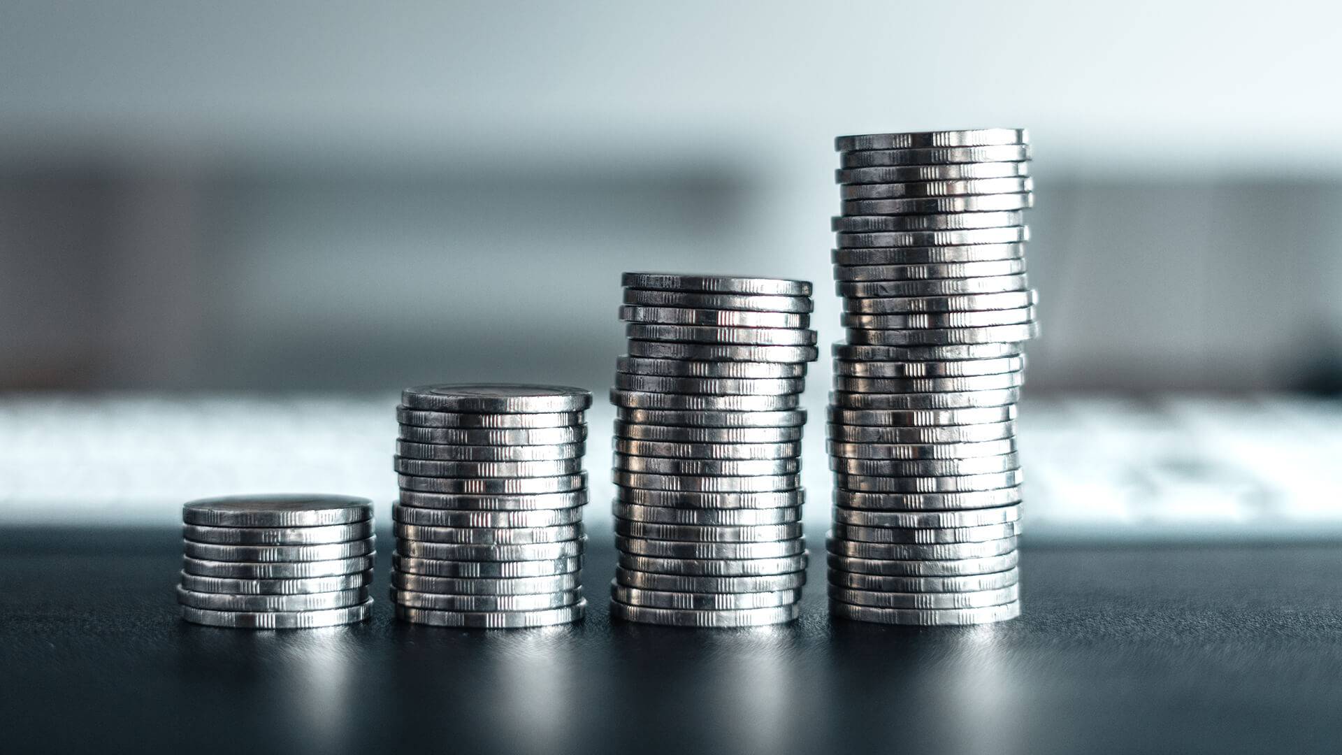 M&uuml;nzenstapel mit Tastaturhintergrund.