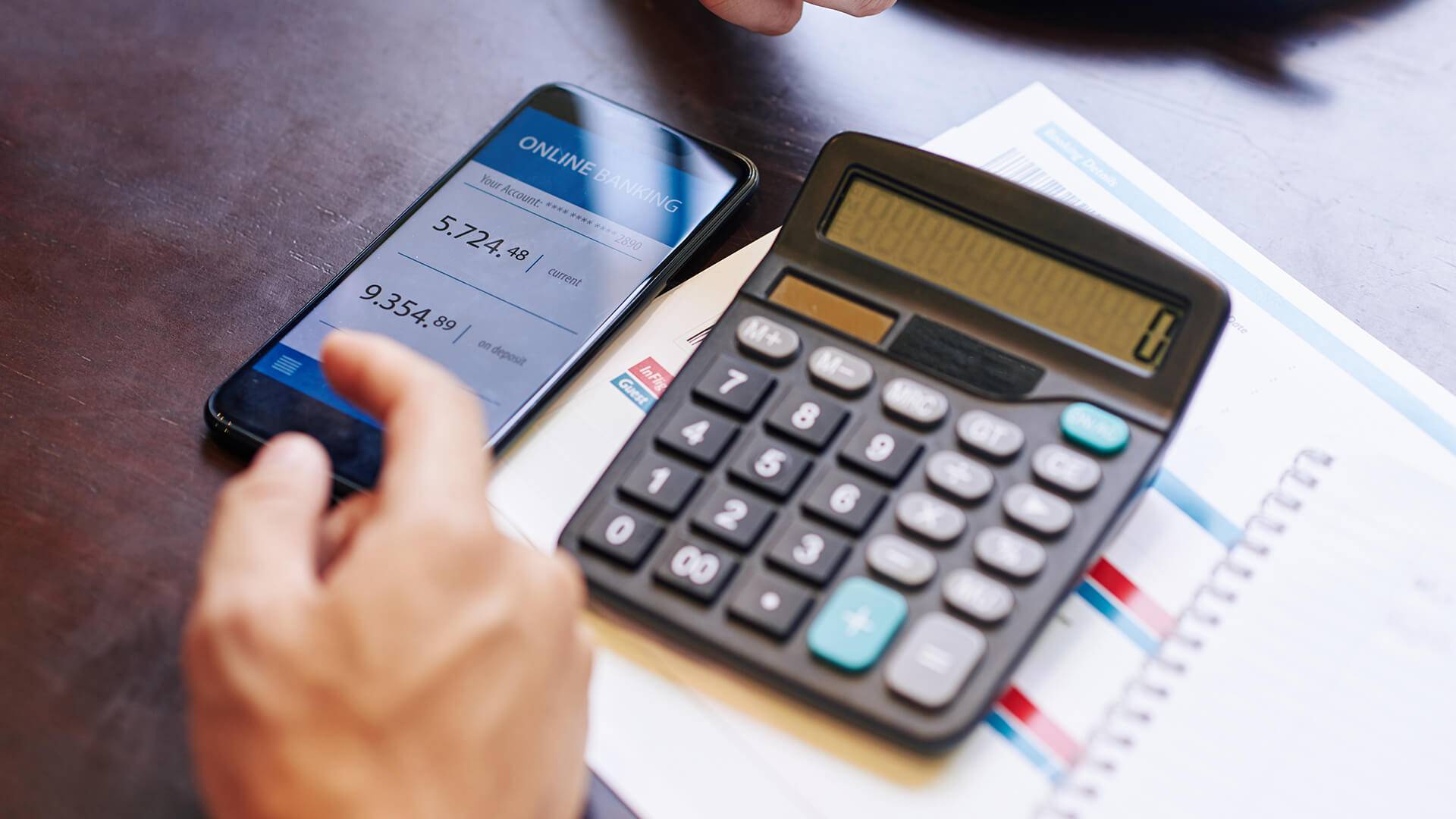 Person h&auml;lt Rechner und Handy.