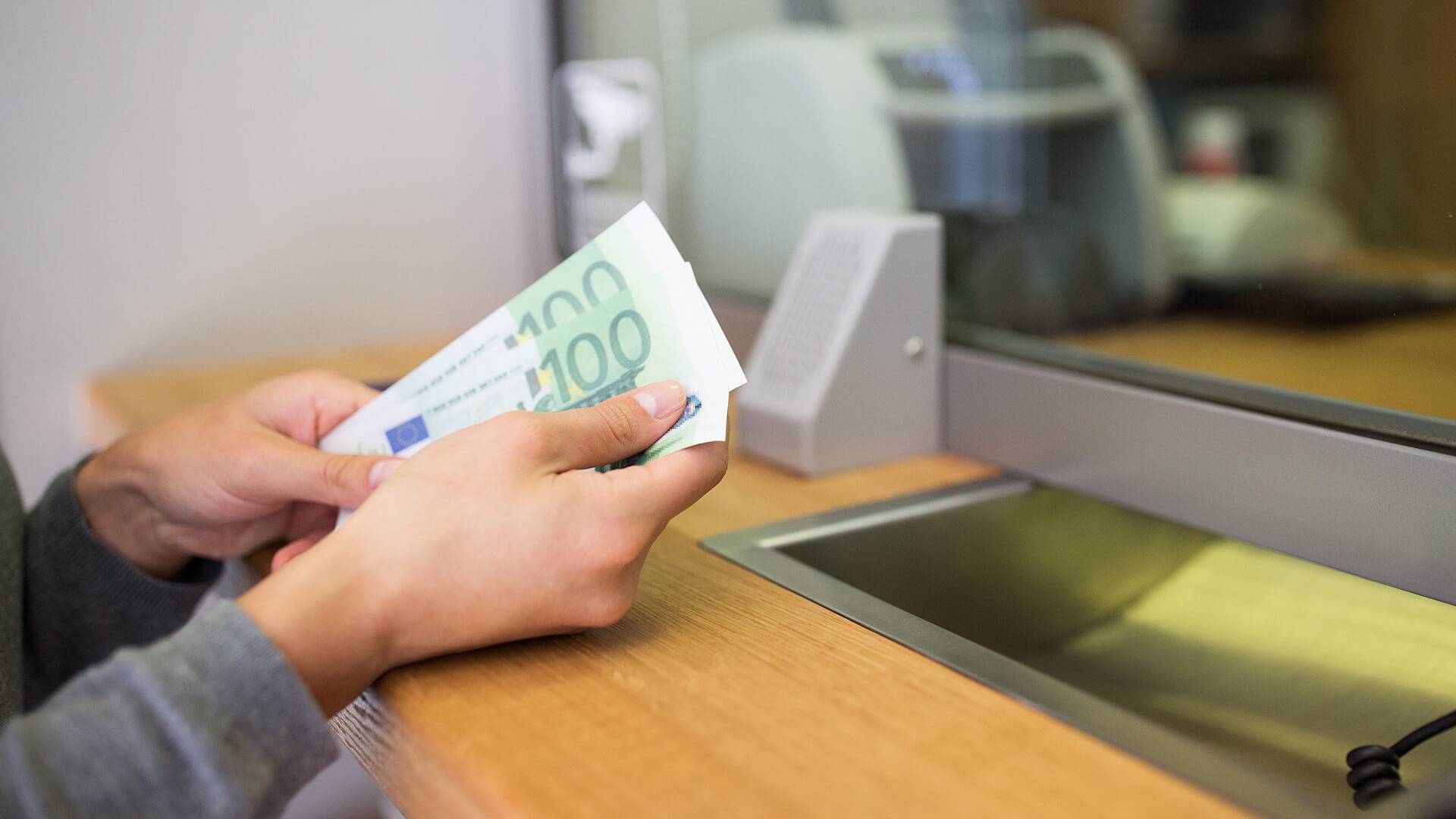Person h&auml;lt Geldb&ouml;rse am Waschbecken.